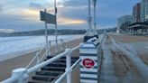 Los efectos del oleaje en Gijón: el paseo del Muro se llena de arena