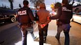U.S. Immigration and Customs Enforcement agents take an arrested immigrant into custody.