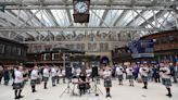 Pipe band surprise crowds at train station