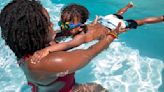 A swim teacher works with a youngster during swim lessons in the Baldwin Hills neighborhood of Los Angeles on July 6, 2021.