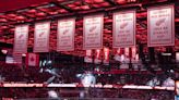 Who are the 8 Red Wings with numbers hanging from LCA rafters?