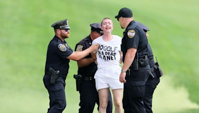 Climate change protestors with smoke bombs storm 18th green at PGA Tour event