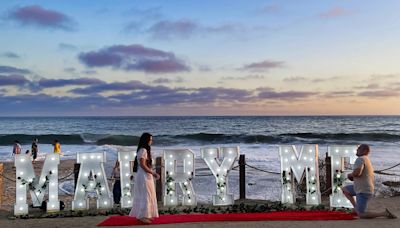 With lighted Marry Me letters on the beach, a proposal is made at Crystal Cove