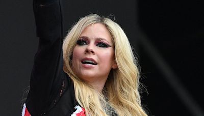 Avril Lavigne is cheered on by Cara Delevingne during Glastonbury set