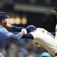 Rhys Hoskins of the Milwaukee Brewers holds back Jose Siri of the Tampa Bay Rays who attempts to go after Brewers pitcher Abner Uribe in a Major League...