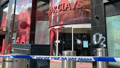 Seven deny criminal damage over bank paint attack