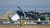 Haneda airport crew remove charred wreckage of Japan Airlines plane from runway