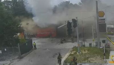 Gas station appears heavily damaged by fire; smoky haze over I-75 in Atlanta