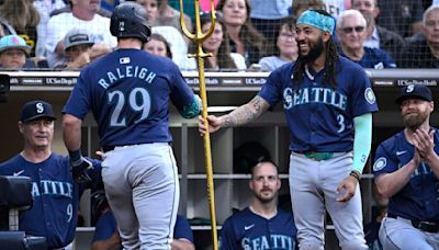 ... Seattle Mariners Cal Raleigh is handed a trident by teammate J.P. Crawford after hitting a two-run home run against the San Diego Padres during the third inning...