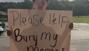 11-year-old Georgia boy holds up heartbreaking sign asking for help to bury his mom