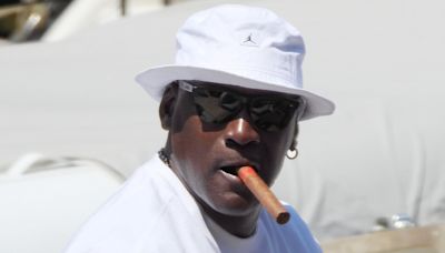 Michael Jordan puffs on a cigar while he and his wife enjoy a stroll