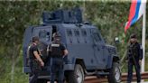 Kosovar police surround a village after gunmen storm a monastery in violence that has killed 4