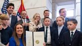 Photo of Sarah Huckabee Sanders beaming next to frowning kids goes viral as child labour laws rolled back