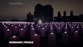 Tombstones of fallen WWII soldiers lit up at cemetery in Normandy as part of D-Day commemorations