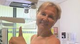 Sue Cleaver holds her thumb up as she gets a mammogram