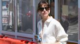 Anne Hathaway Pairs an Oversized Ivory Blouse with Creamy Short Shorts