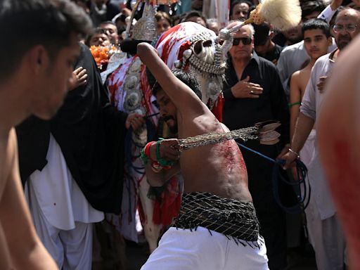 Shi'ite Muslim devotees whip themselves with sharp blades