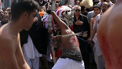 Shi'ite Muslim devotees whip themselves with sharp blades