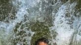 A child playfully takes a dip in a lake to get respite from the heat in Dhaka, Bangladesh