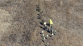 North Korean army soldiers head to cross the Military Demarcation Line inside the Demilitarized Zone (DMZ) to inspect the dismantled South Korean guard post in Cheorwon