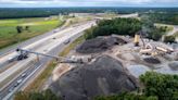 Rising over the highway, conveyor belt carries hot asphalt to I-40 construction zone