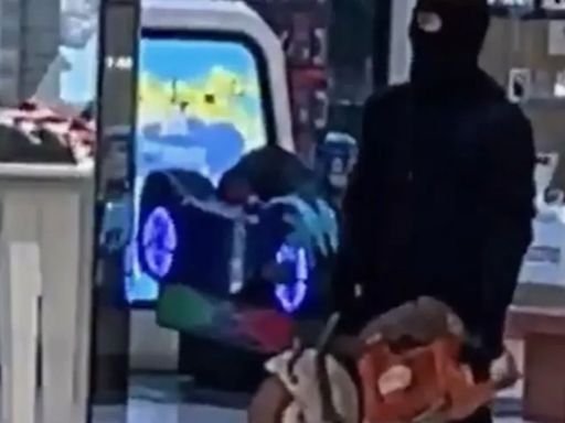 Shock moment masked robber brandishes circular saw in shopping centre