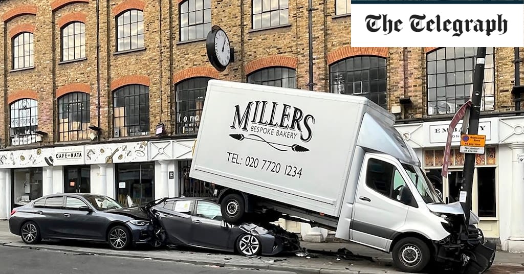 Pictured: Crumpled bakery van sandwiched between lamppost and two cars after crash