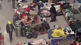 Migrants continue to stream into Boston airport as more than 100 sleep on the floor