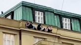 Prague shooting: Footage shows people cowering on ledge of university building as police hunt gunman