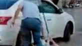 Horrifying moment taxi driver tears elderly woman from car to rob her before nearly running over bystander