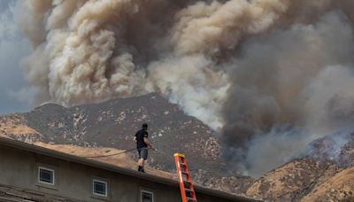 Residents flee as California and Nevada wildfires get dangerously close and forecasters warn of record heat