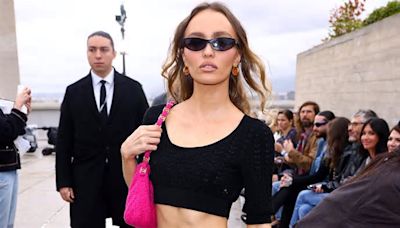 Lily-Rose Depp flaunts her washboard abs in a black crop top and pink mini skirt as she poses at the star-studded Chanel Cruise show in Marseille