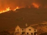 A house is threatened as the Airport Fire gains ground near Lake Elsinore