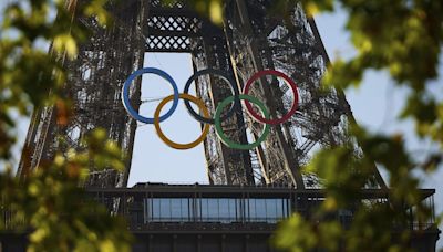 Nur noch 49 Tage, dann geht's los; Gigantische Olympische Ringe am Eiffelturm angebracht.