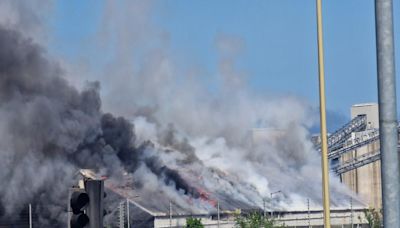 Thick black clouds of smoke as major fire breaks out in grain warehouse at port