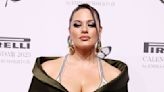 Ashley Graham mugs for the camera while wearing a golden bust