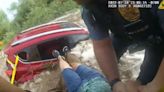 Footage shows police pull trapped woman from submerged car amid flooding