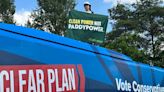 Greenpeace protester climbs on top of Conservative election campaign bus