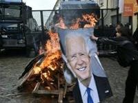 Activists burn a portrait of US President Joe Biden and G7 leaders during a demonstration against the G7 Climate, Energy and Environment held in Turin, on April 28