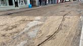 Flash flood rips up road and leaves it 'like beach'