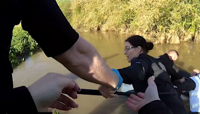 Watch the terrifying moment brave officers form human chain to rescue woman from sinking car