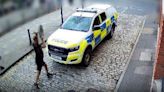 Watch the moment far-right yob throws concrete parasol stand at police car