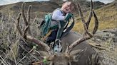 Toddler poses on antlers of enormous buck - with the arrow still in it