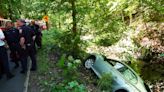 Trapped woman rescued after car gets perched over creek