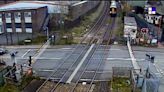 Pedestrian seconds away from being hit by train after climbing barrier at railway crossing