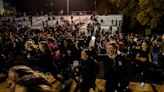 Male football fans storm the field after beating Manual. Except the game wasn't over yet