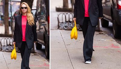 Jennifer Lawrence combina su bolsa color amarillo plátano con blusa fucsia y pantalones elegantes