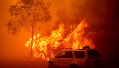 Lightning and a burning car pushed into a gully are blamed for wildfires scorching the West