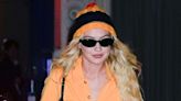 Gigi Hadid Steps Out in Bright Orange Boiler Suit and Matching Striped Pom Pom Hat