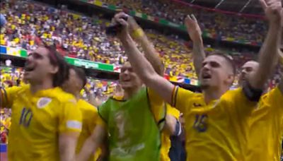 Romania stars lead chants with a megaphone after beating Ukraine